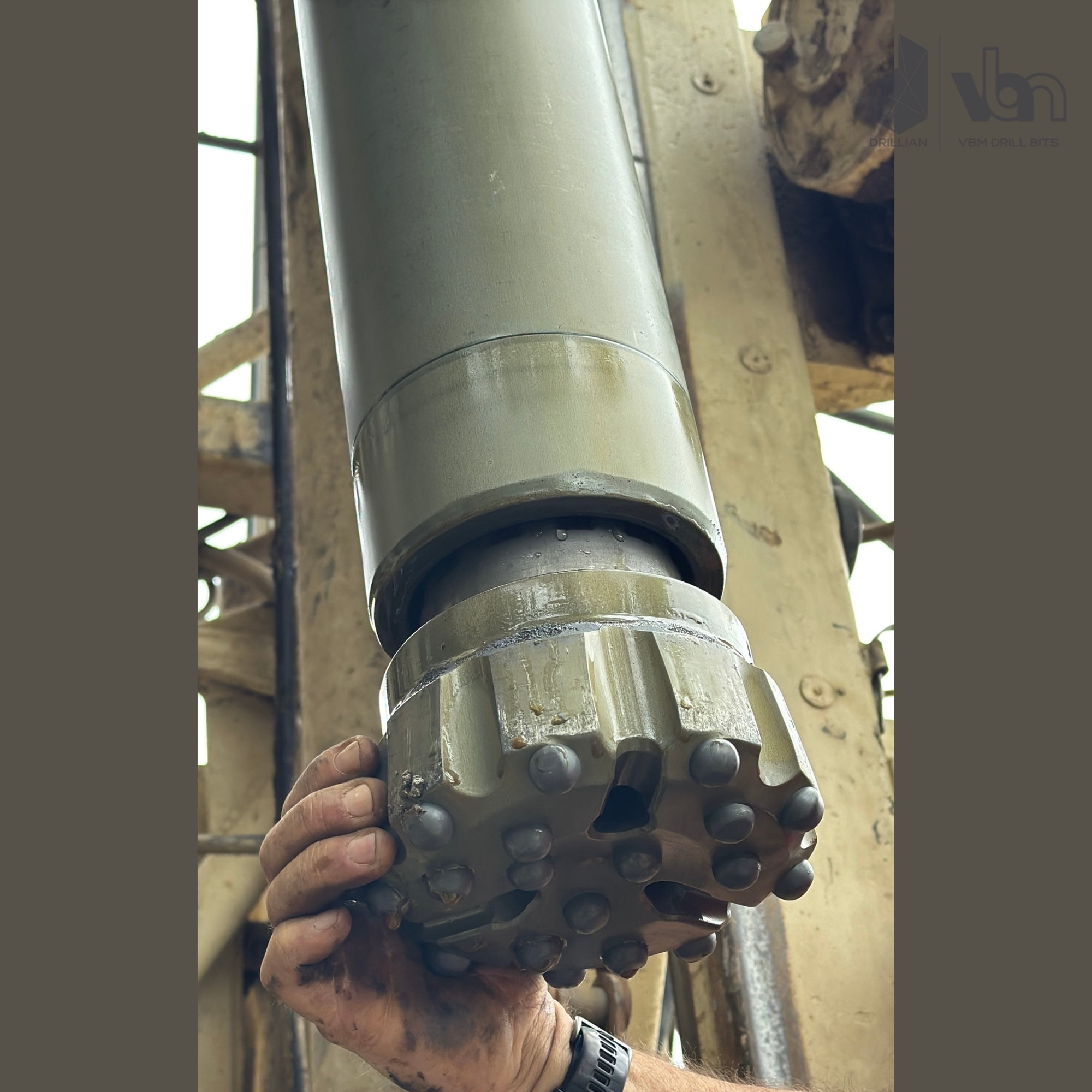6 3/4 inch DTH bit with dome TCI buttons attached to a DTH hammer on the drill rig after hard rock drilling